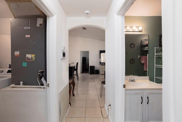 bathroom with tile patterned floors, vanity, and lofted ceiling