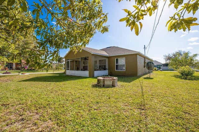 back of property with a yard and a sunroom