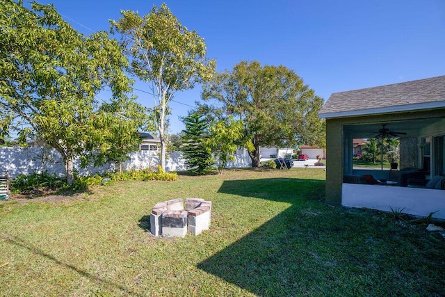 view of yard with ceiling fan and a fire pit