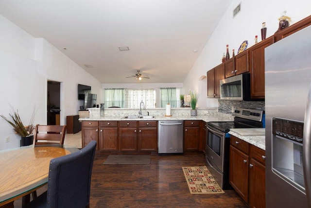 kitchen featuring sink, vaulted ceiling, ceiling fan, appliances with stainless steel finishes, and tasteful backsplash