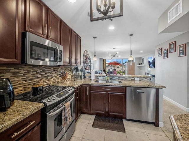 kitchen featuring sink, stainless steel appliances, kitchen peninsula, a chandelier, and decorative light fixtures