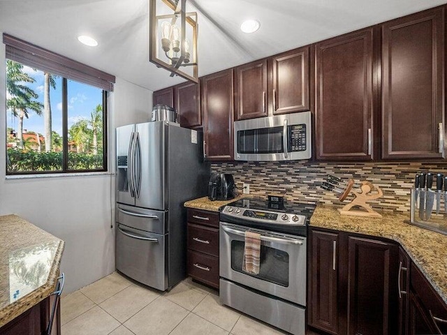 kitchen featuring light stone countertops, decorative light fixtures, decorative backsplash, light tile patterned floors, and appliances with stainless steel finishes