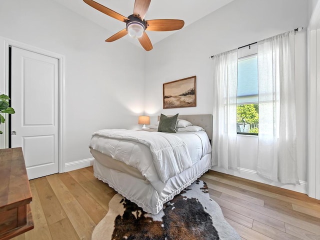 bedroom with vaulted ceiling, ceiling fan, and light hardwood / wood-style flooring