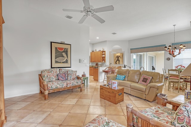 tiled living room featuring ceiling fan with notable chandelier