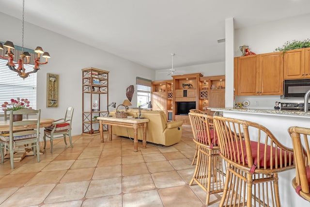 kitchen featuring ceiling fan with notable chandelier and decorative light fixtures