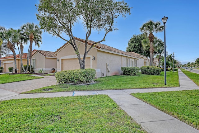 view of front of home with a garage and a front lawn