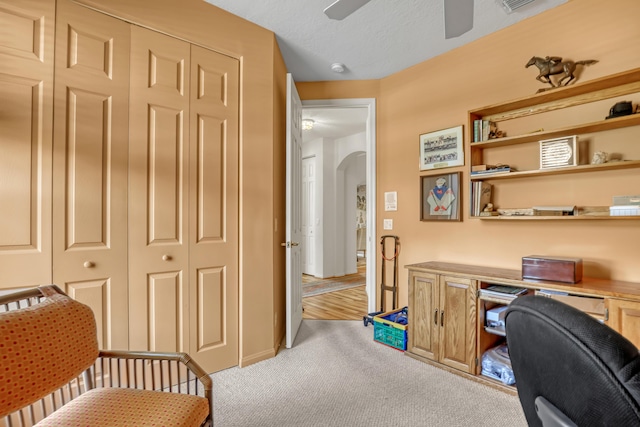 office space with ceiling fan and light carpet