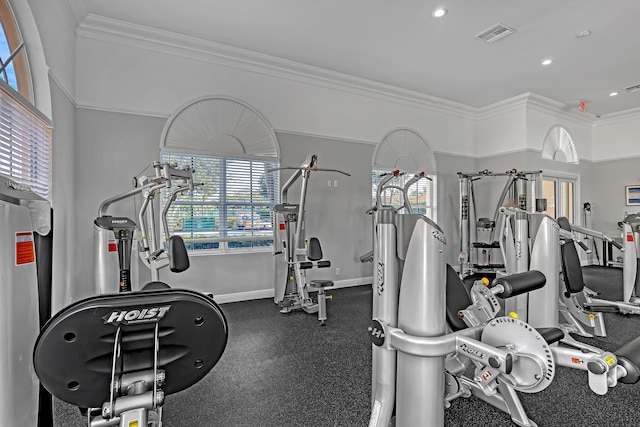 workout area featuring water heater and crown molding