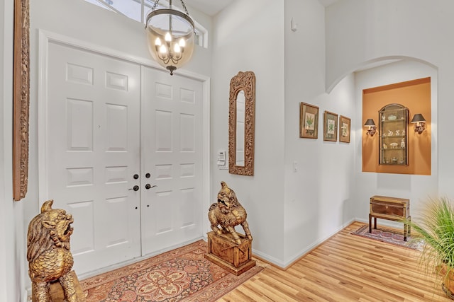 foyer entrance with an inviting chandelier and light hardwood / wood-style floors