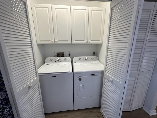 laundry room with separate washer and dryer and cabinets