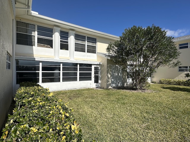 back of property featuring a lawn