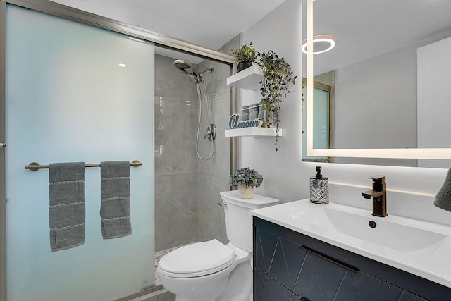 bathroom featuring vanity, a shower with shower door, and toilet