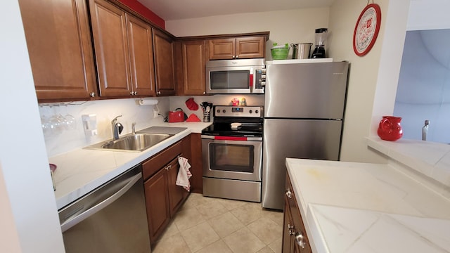 kitchen featuring decorative backsplash, appliances with stainless steel finishes, light tile patterned flooring, and sink