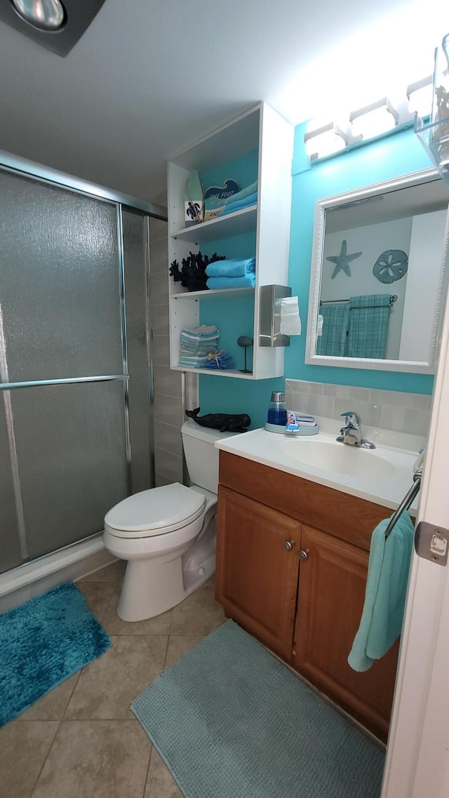 bathroom featuring tile patterned floors, vanity, walk in shower, and toilet