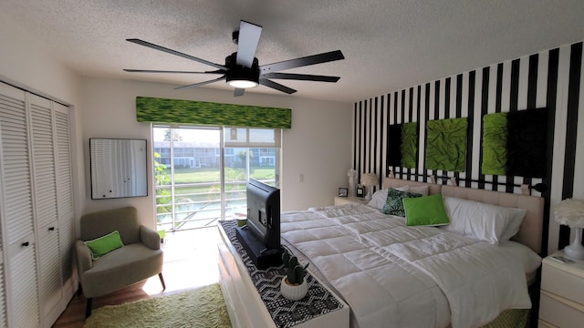 bedroom featuring ceiling fan, access to exterior, a textured ceiling, and a closet