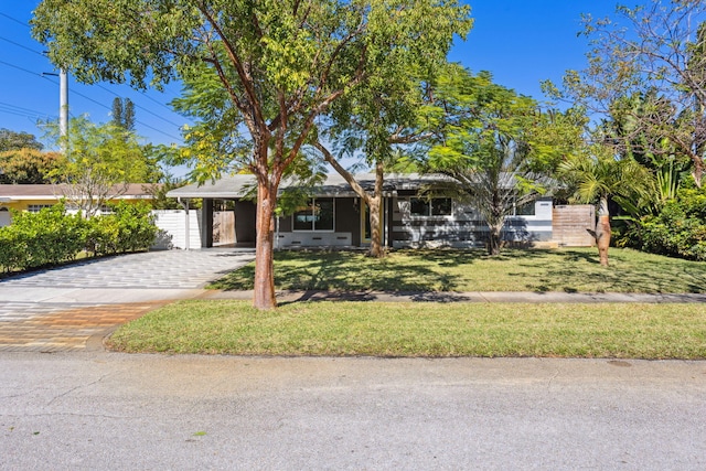 ranch-style home featuring a carport and a front lawn