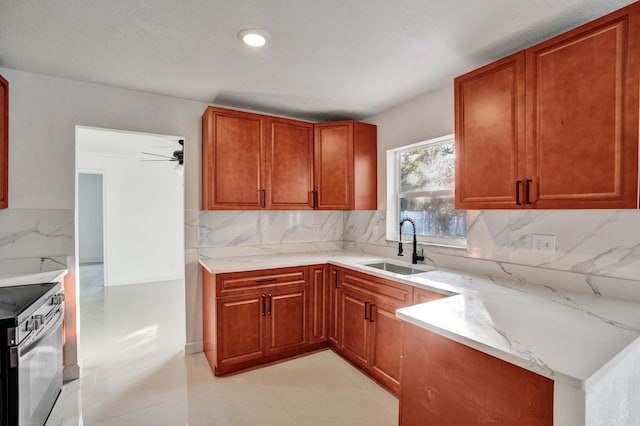 kitchen with sink, decorative backsplash, stainless steel electric range oven, and light stone countertops