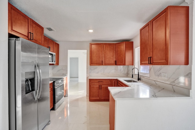 kitchen with stainless steel appliances, light stone countertops, kitchen peninsula, decorative backsplash, and sink