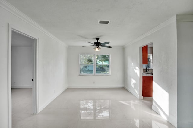 spare room featuring sink, ceiling fan, and ornamental molding