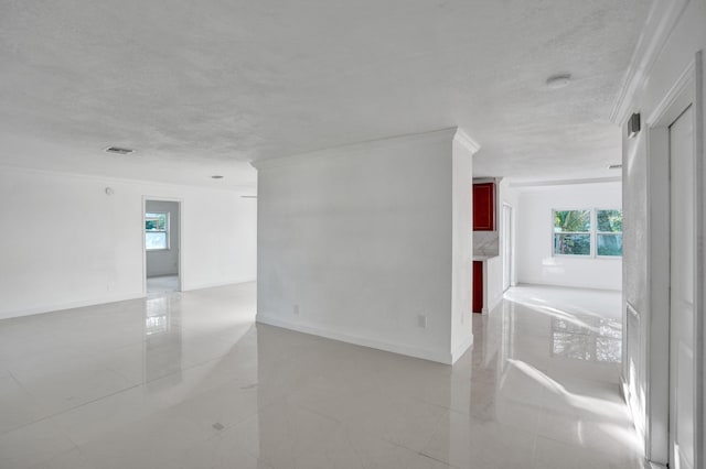 empty room with a textured ceiling and ornamental molding