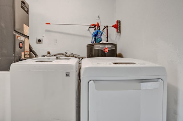 laundry room featuring water heater and independent washer and dryer