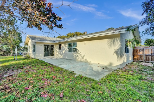 rear view of property featuring a patio and a yard