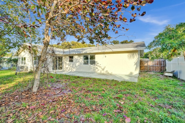 back of house featuring a yard and a patio