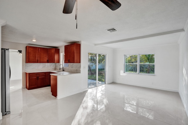 kitchen featuring sink, ceiling fan, backsplash, and crown molding