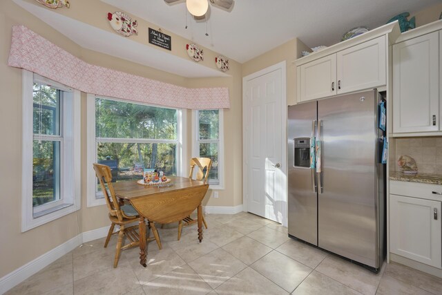 kitchen with tasteful backsplash, white cabinetry, light stone countertops, and stainless steel appliances