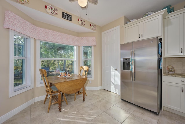 kitchen featuring a healthy amount of sunlight, tasteful backsplash, white cabinetry, and stainless steel fridge with ice dispenser