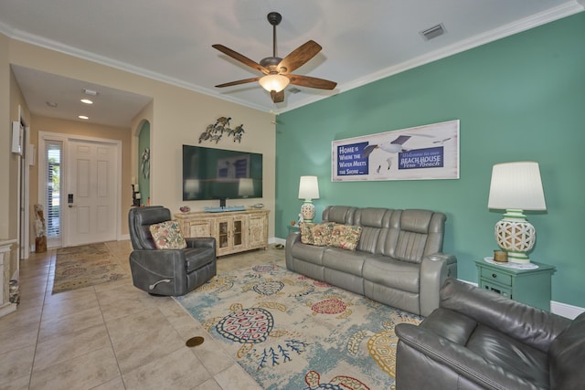 living area with arched walkways, visible vents, ornamental molding, tile patterned flooring, and baseboards