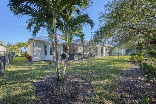 back of property featuring a lanai and a yard