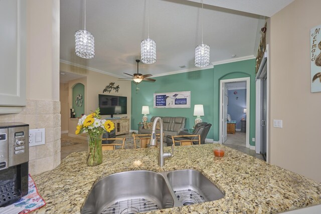 kitchen with kitchen peninsula, stainless steel dishwasher, sink, decorative light fixtures, and white cabinets