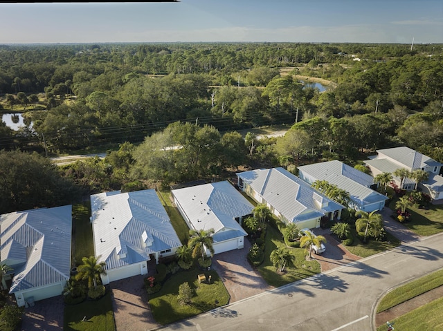 birds eye view of property featuring a water view and a forest view