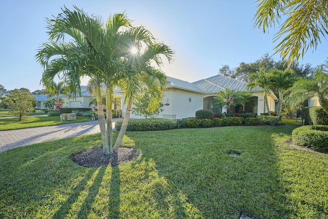 view of front of house with a front lawn, decorative driveway, and stucco siding