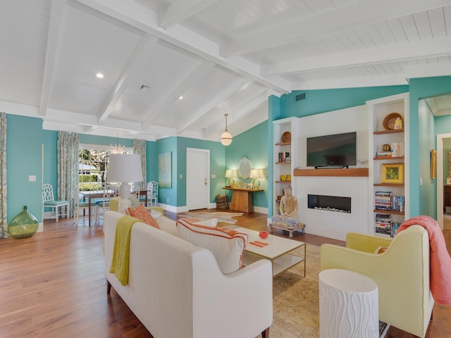 living room featuring hardwood / wood-style flooring, lofted ceiling with beams, and built in features