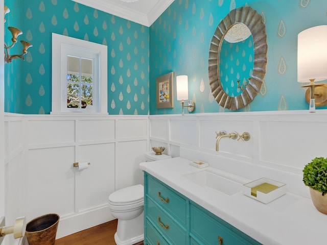 bathroom featuring vanity, hardwood / wood-style flooring, toilet, and ornamental molding