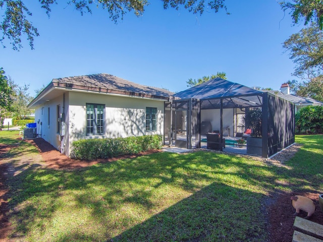 back of house featuring a yard, a pool, and a lanai