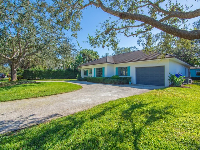 ranch-style home with cooling unit, a garage, and a front yard