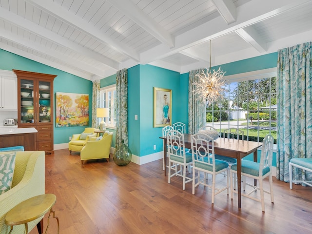 dining area with lofted ceiling with beams, light wood-type flooring, and an inviting chandelier