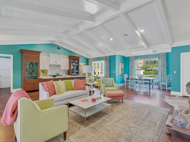 living room with a chandelier, light hardwood / wood-style flooring, and lofted ceiling with beams