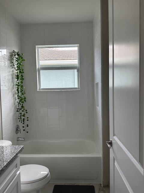 full bathroom with toilet, vanity, and tiled shower / bath combo