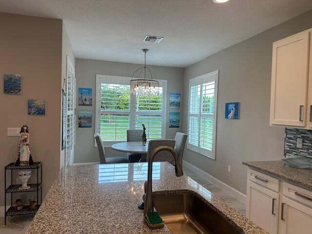 dining space with sink and a notable chandelier