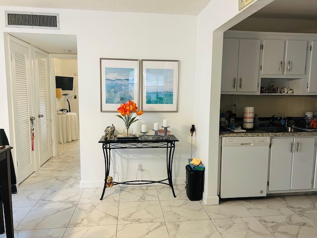 kitchen featuring sink, gray cabinetry, white dishwasher, a textured ceiling, and decorative backsplash