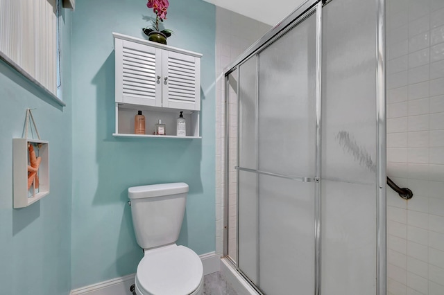 bathroom with toilet and a shower with shower door