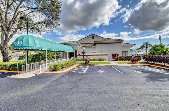 view of property with uncovered parking and fence
