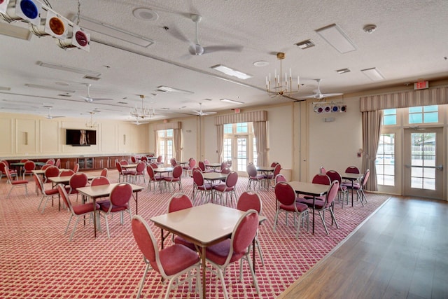 dining space with visible vents, a textured ceiling, and wood finished floors