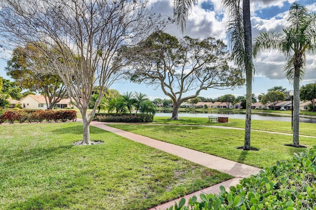 view of property's community with a lawn and a water view
