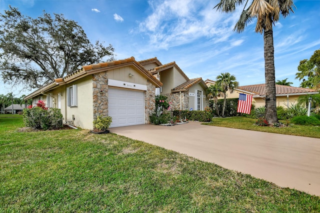 view of front of property with stucco siding, a front lawn, driveway, a tile roof, and an attached garage
