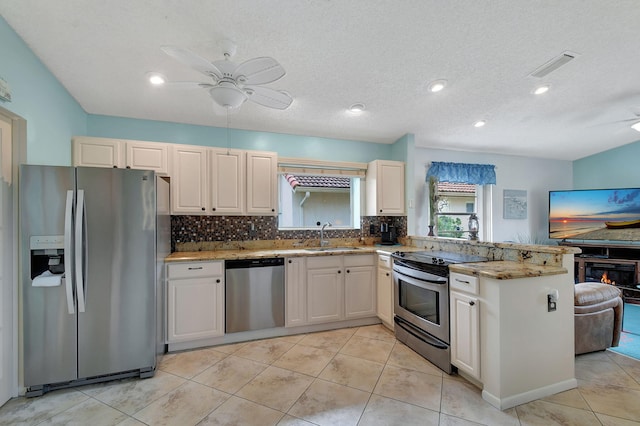 kitchen featuring sink, stainless steel appliances, a textured ceiling, and ceiling fan